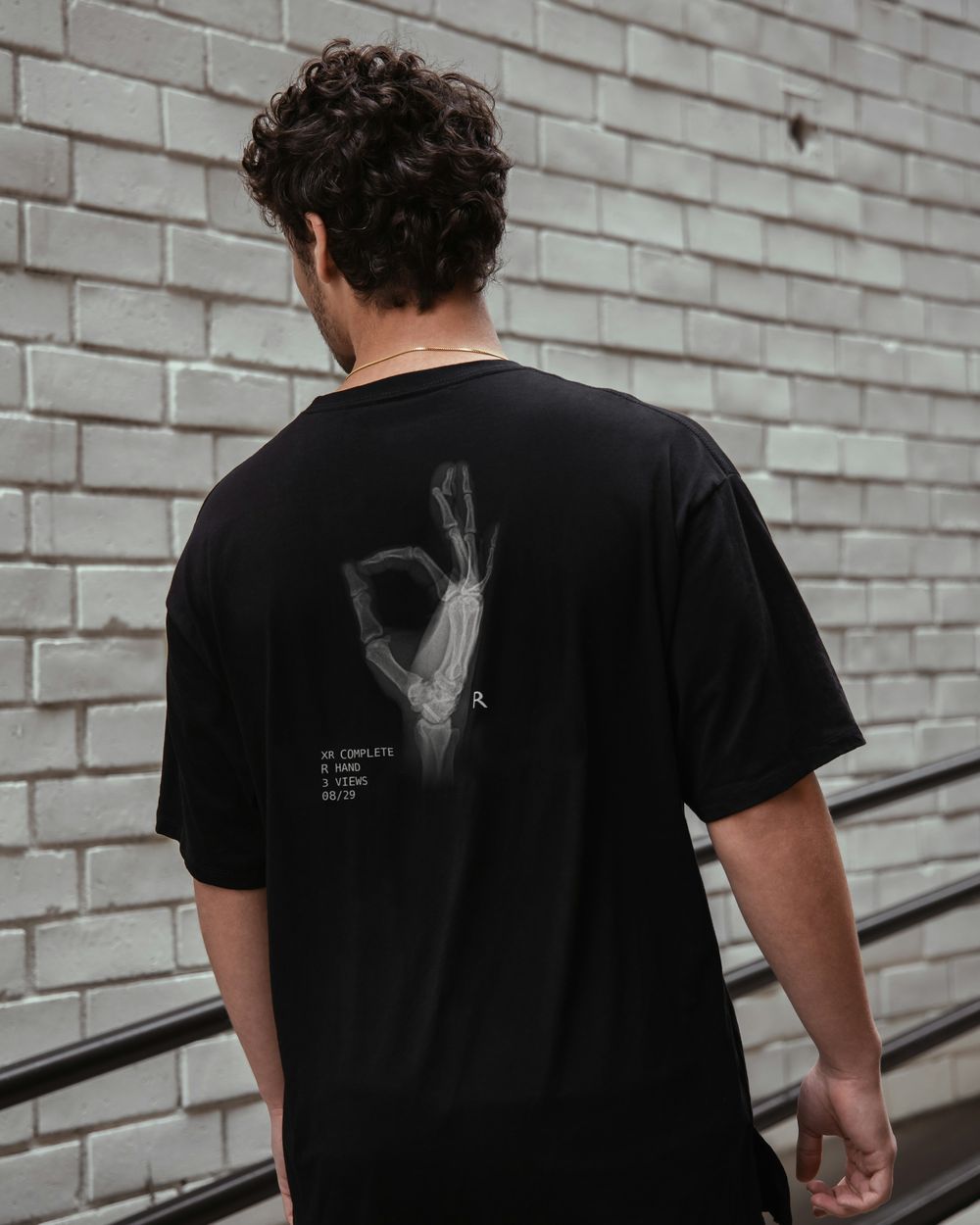 Model in the black tee, seen from behind